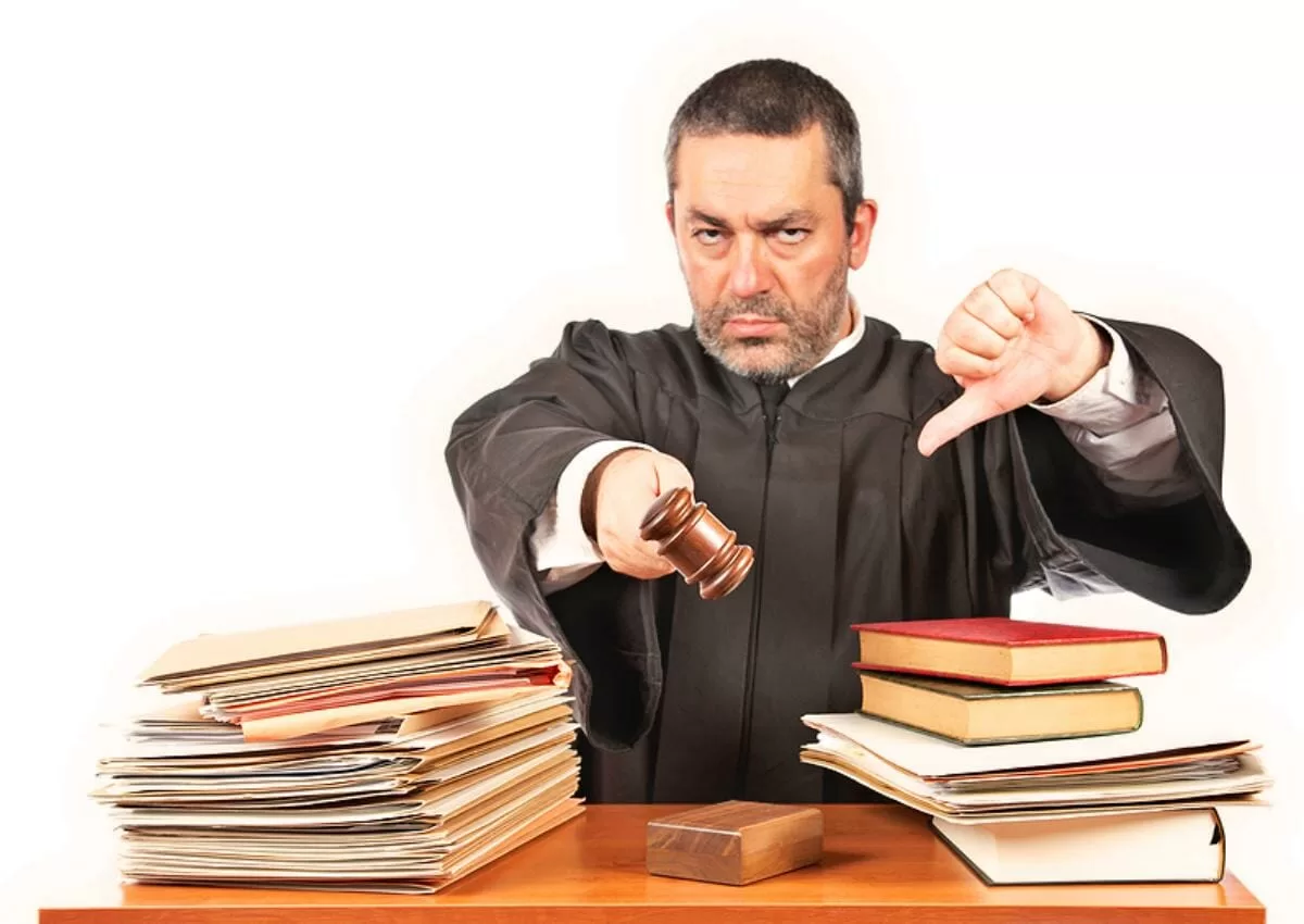 Angry male judge in a courtroom striking the gavel and pronounces sentence. Focus at front y very shallow depth of field